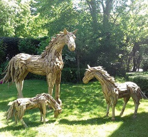 3 driftwood horses in a garden