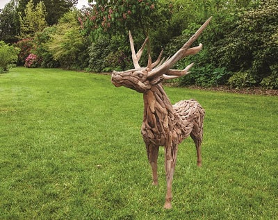 Driftwood stag made from teak tree roots on grass