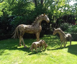 driftwood horse sculptures in a beautiful garden